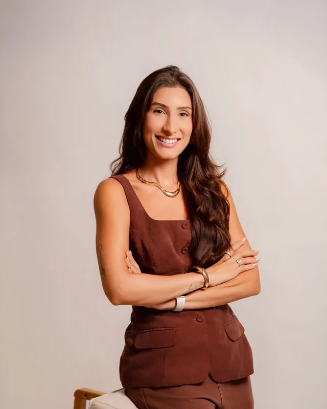 Natália Dadalto de braços cruzados, sorrindo