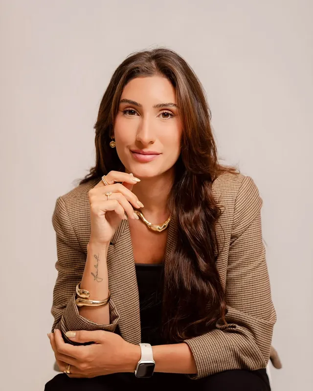 Natália Dadalto de blazer, olhando para a câmera
